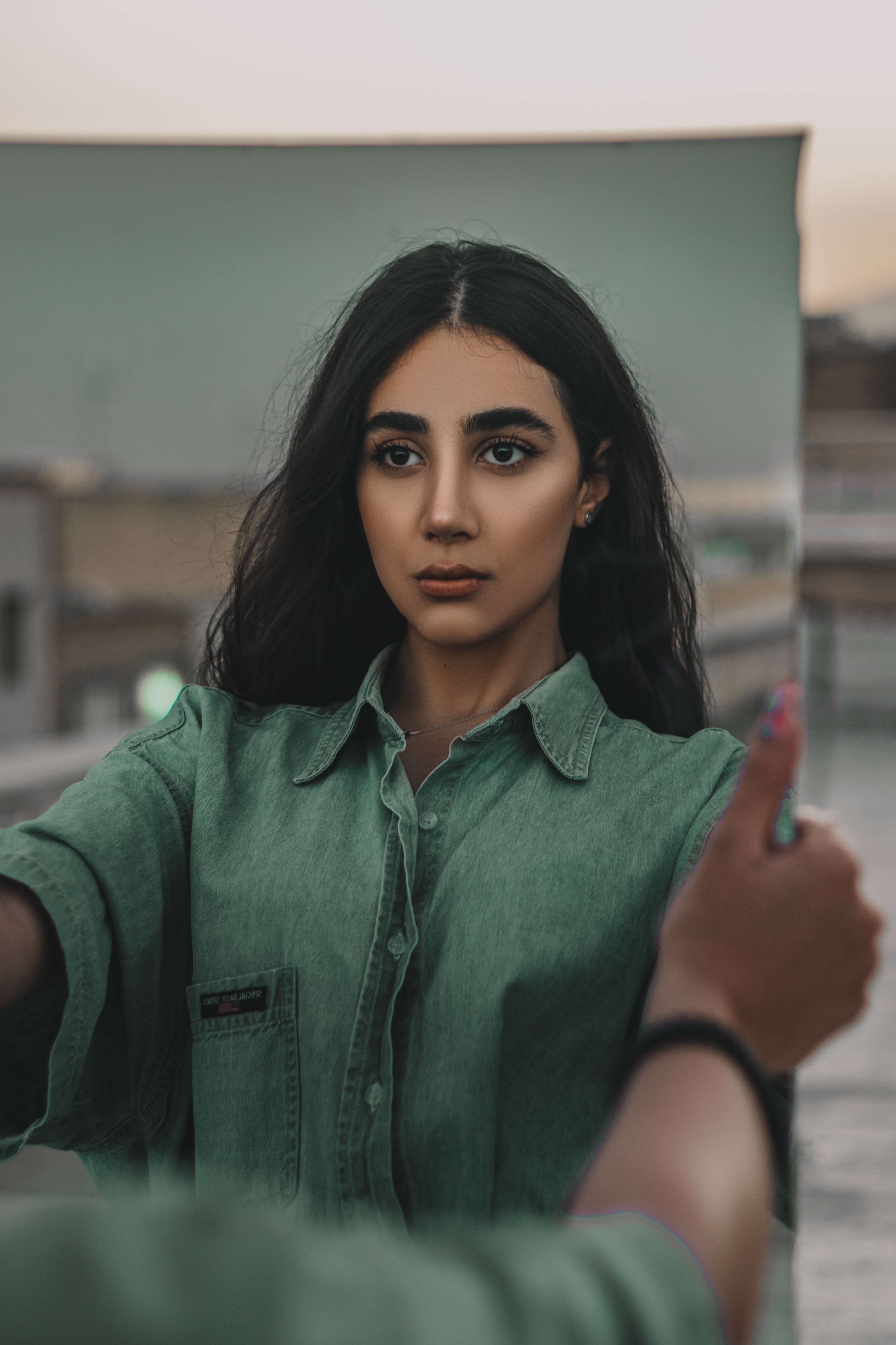 person looking at reflection in mirror